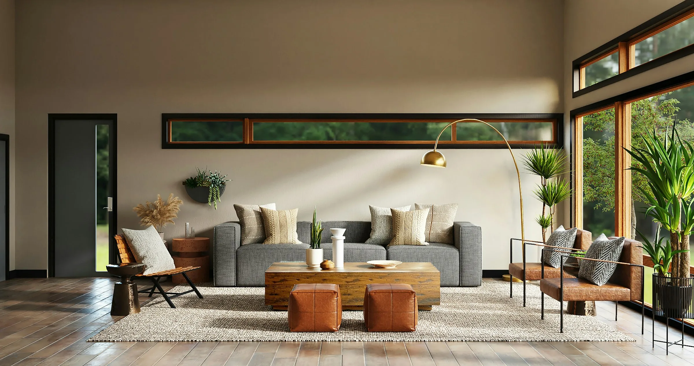 Open-plan living room with a grey modular sofa, brass arc floor lamp, leather armchairs and full-height windows onto greenery